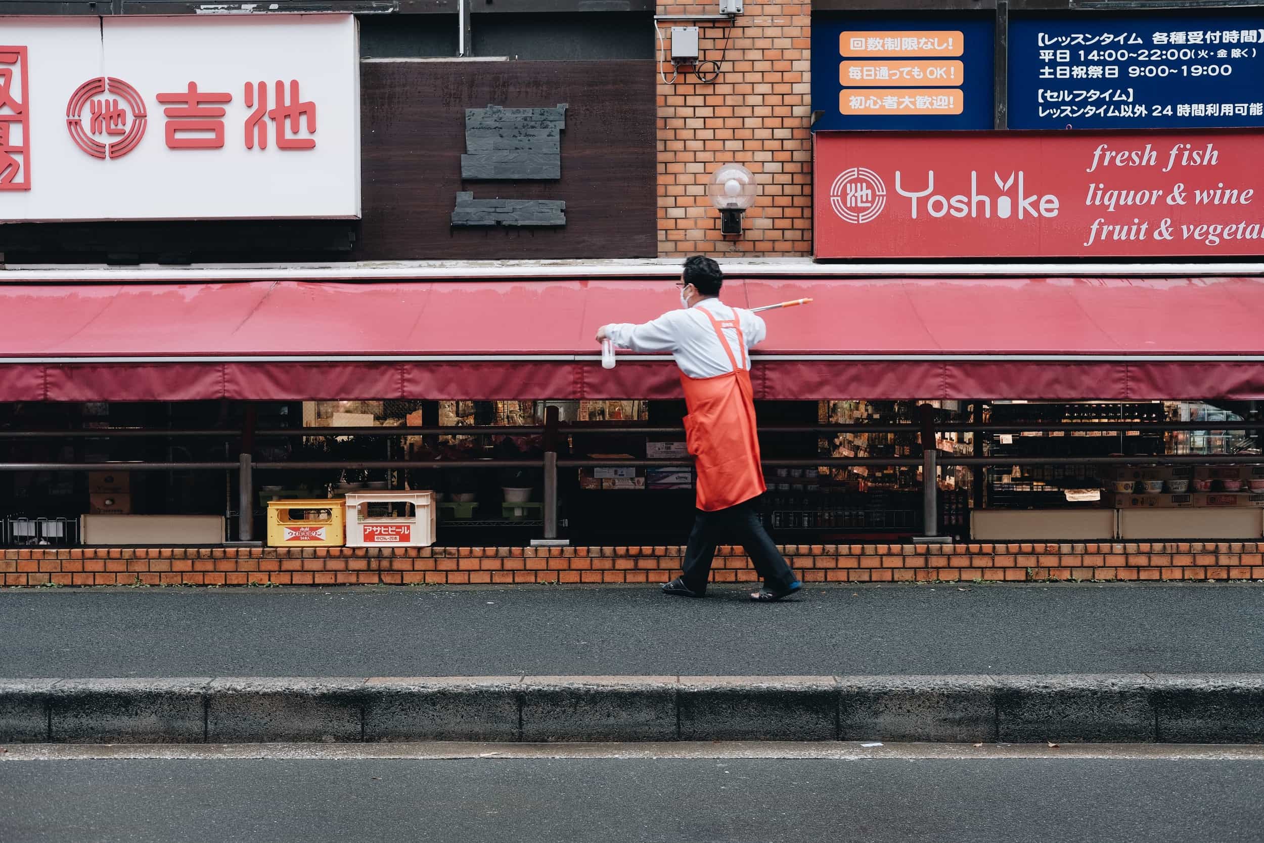 A man cleaning up in front of a supermarket